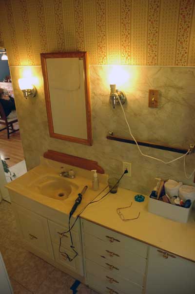 Looking from the toilet to the sink and entrance