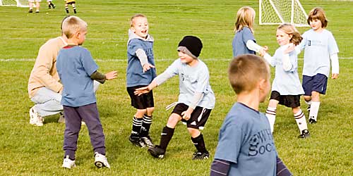 The kids congratulate each other on a game well played. Mostly, they jump on and hug their friends.