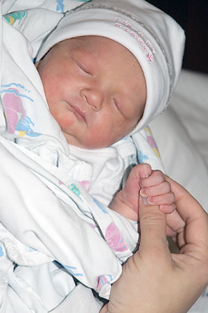 [photo of Isabel gripping Kim's finger]