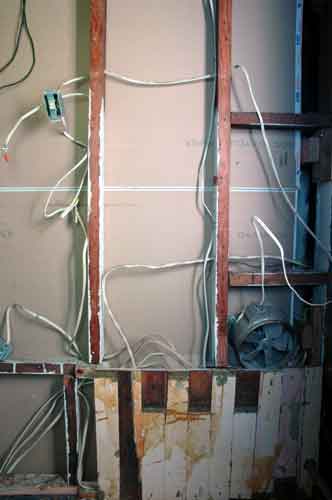 This mess of wires is holding us up; on the other side of the lower wall is the electrical panel.